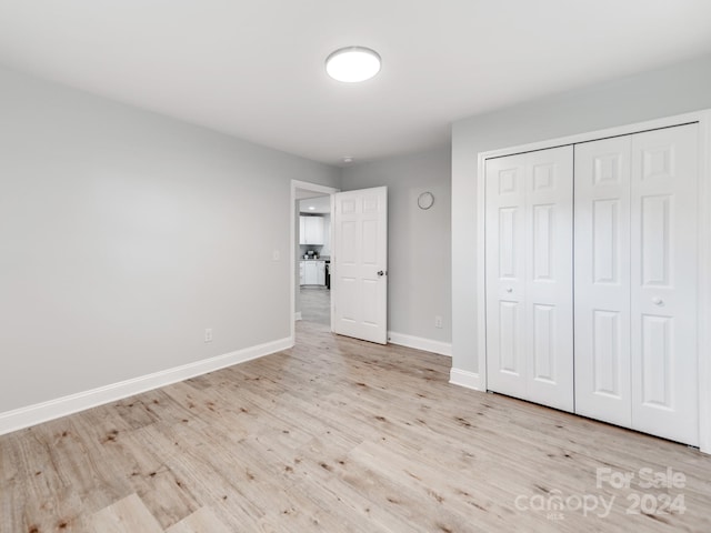 unfurnished bedroom featuring a closet and light wood-type flooring