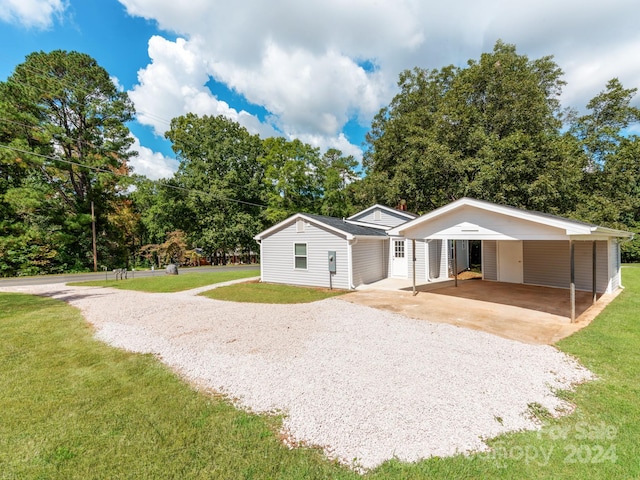 ranch-style house featuring a carport and a front lawn