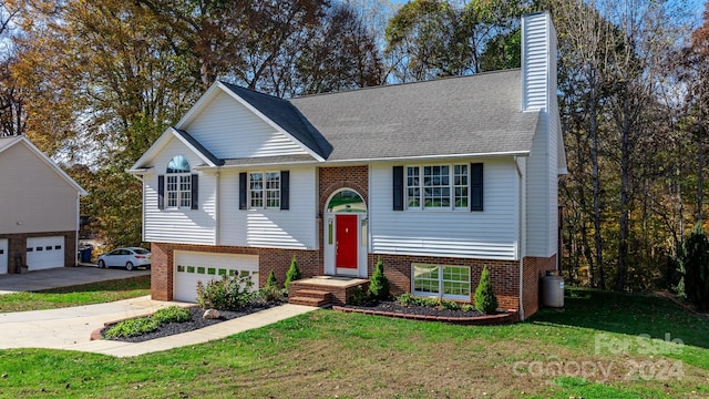 split foyer home featuring a garage and a front yard