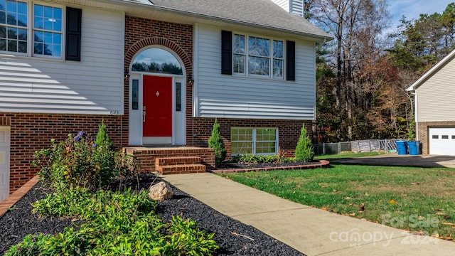 doorway to property featuring a lawn and a garage