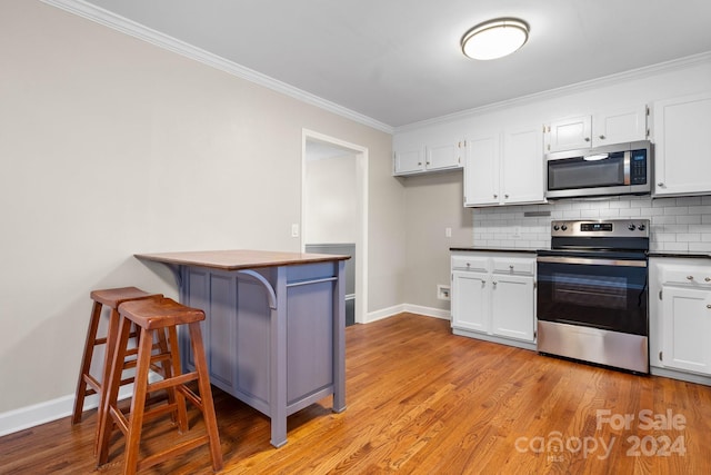 kitchen with white cabinetry, appliances with stainless steel finishes, and light hardwood / wood-style floors