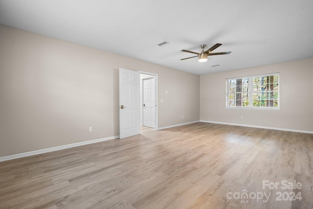 empty room featuring ceiling fan, a textured ceiling, and light hardwood / wood-style floors