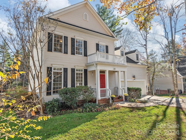 view of front facade with a garage, a front lawn, and a balcony