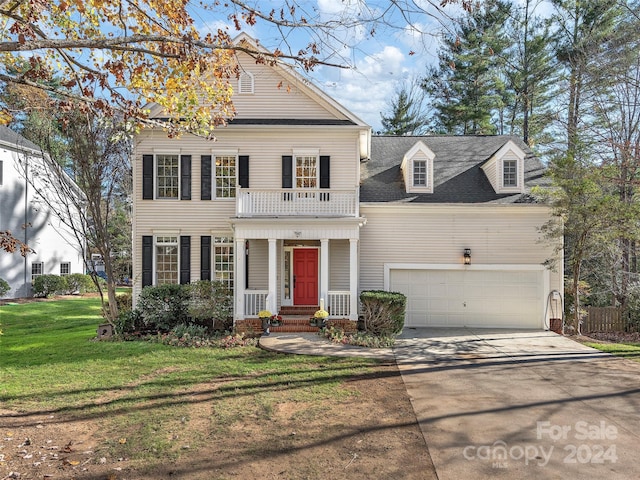 view of front facade with a garage, a front lawn, a balcony, and a porch