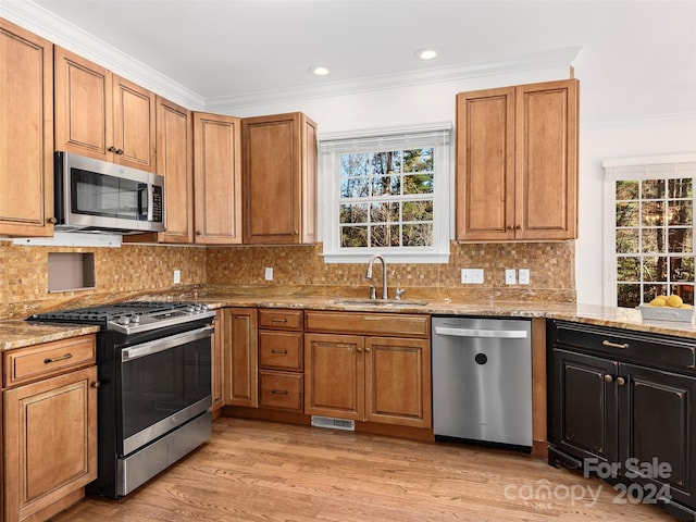 kitchen featuring light hardwood / wood-style floors, appliances with stainless steel finishes, sink, and light stone counters