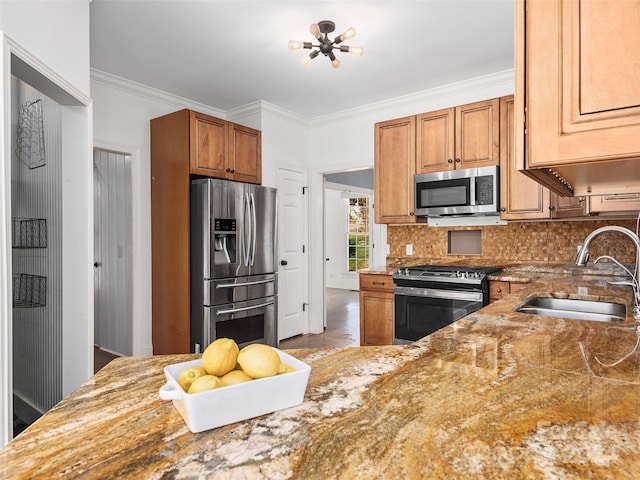 kitchen featuring sink, light stone counters, ornamental molding, and stainless steel appliances