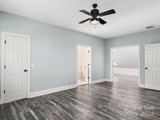 empty room with ceiling fan and dark hardwood / wood-style flooring