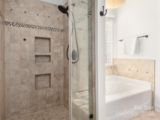 bathroom featuring tile patterned flooring and shower with separate bathtub