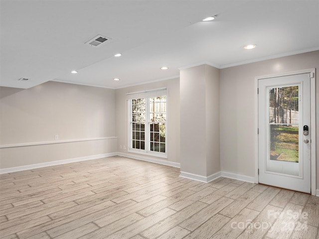 empty room featuring light wood-type flooring and ornamental molding