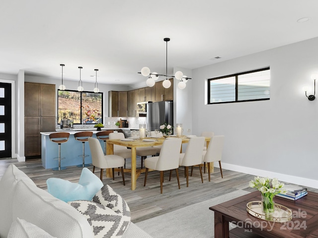 dining area with light hardwood / wood-style floors and a chandelier