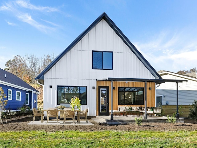 rear view of property with a yard, a patio, and an outdoor living space