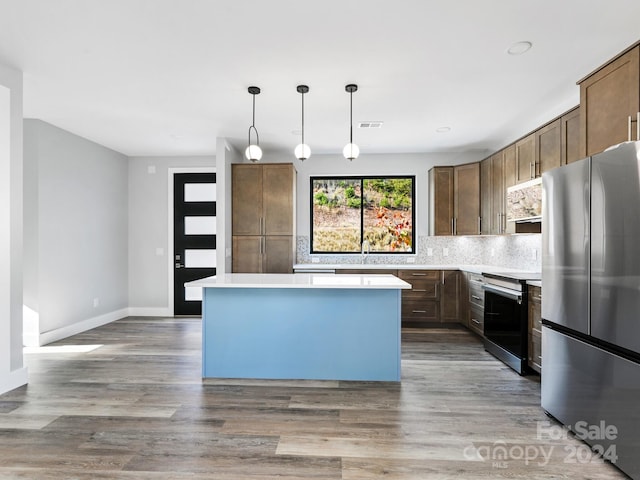 kitchen featuring hardwood / wood-style floors, appliances with stainless steel finishes, hanging light fixtures, and a center island