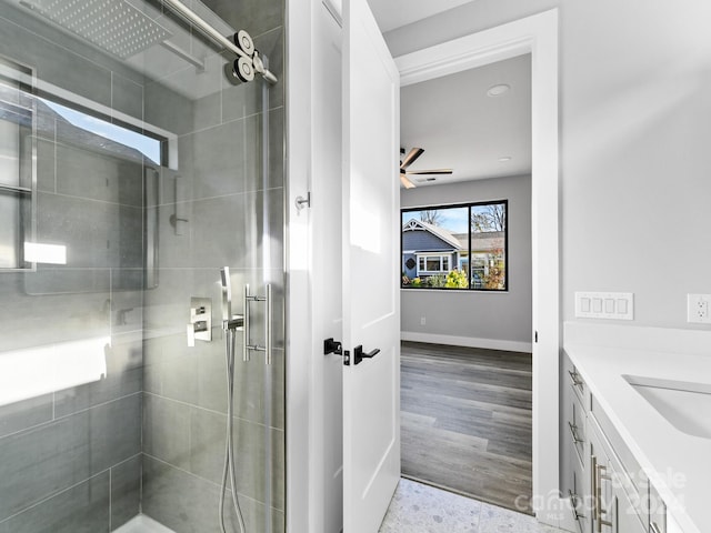 bathroom with a shower with door, wood-type flooring, ceiling fan, and vanity