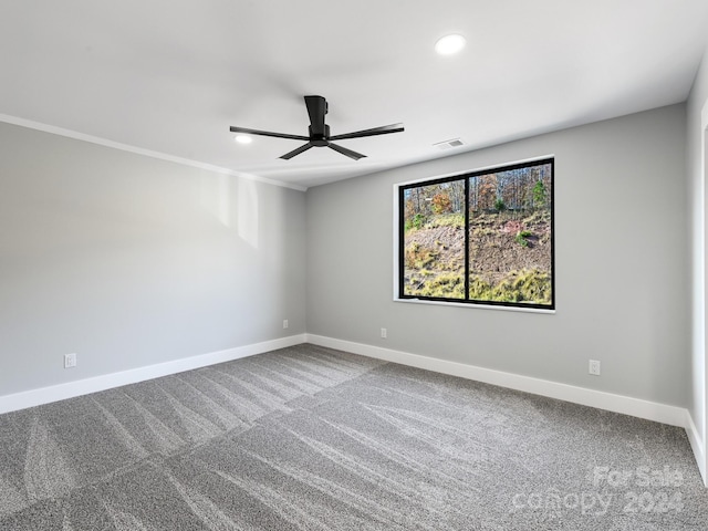 carpeted spare room featuring ornamental molding and ceiling fan