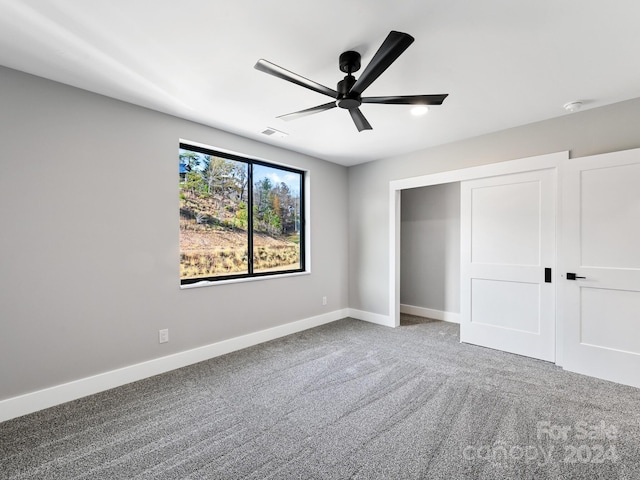 unfurnished bedroom featuring a closet, ceiling fan, and carpet floors