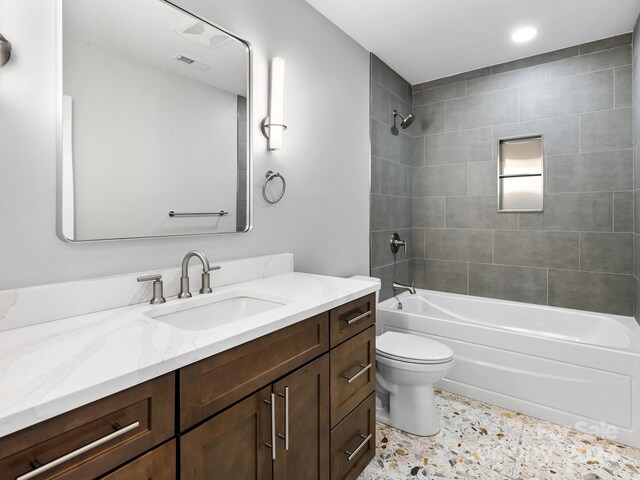 full bathroom featuring toilet, vanity, and tiled shower / bath