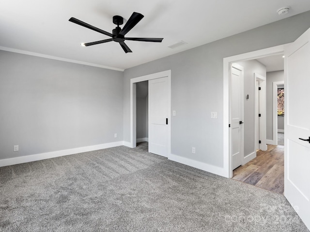 unfurnished bedroom featuring a closet, light colored carpet, and ceiling fan