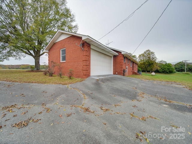 view of side of property with a garage and a lawn