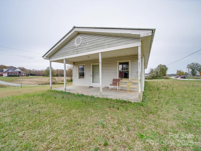 rear view of house with a lawn and covered porch