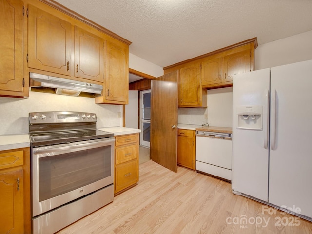 kitchen with a textured ceiling, white appliances, and light wood-type flooring