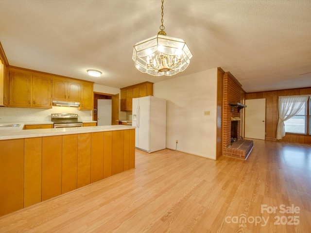 kitchen featuring kitchen peninsula, stainless steel electric stove, white fridge with ice dispenser, a notable chandelier, and hanging light fixtures