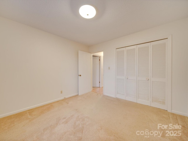 unfurnished bedroom featuring a textured ceiling, carpet floors, and a closet