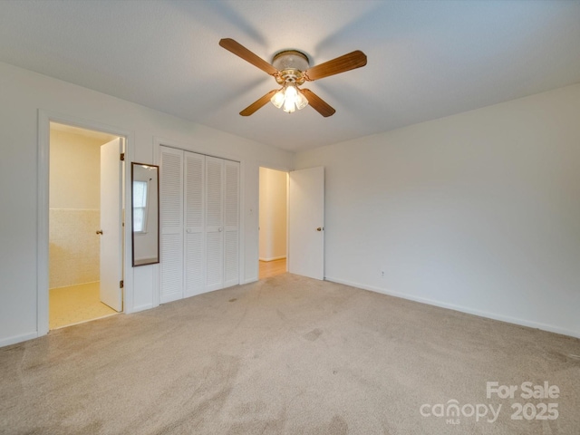 unfurnished bedroom featuring light carpet, connected bathroom, a closet, and ceiling fan