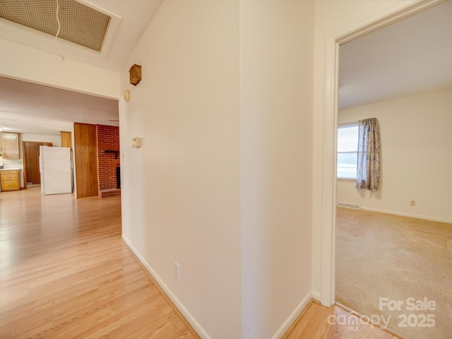 hallway with light hardwood / wood-style floors