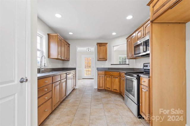 kitchen featuring light tile patterned flooring, sink, and appliances with stainless steel finishes