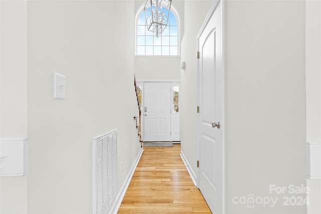 doorway with light hardwood / wood-style flooring and an inviting chandelier