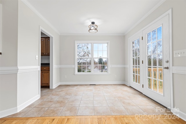 unfurnished dining area with light wood-type flooring and crown molding