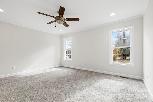 carpeted spare room featuring ceiling fan and crown molding