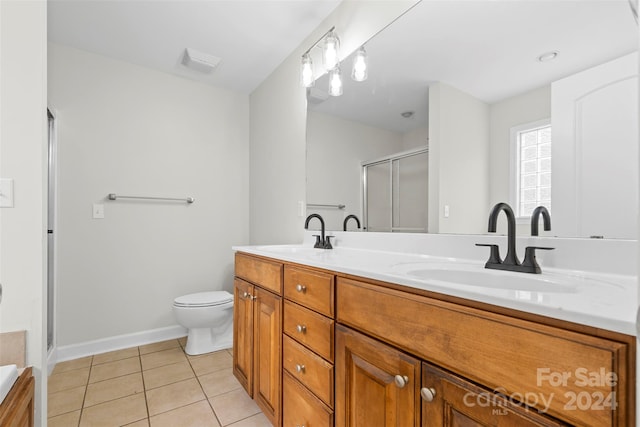 bathroom featuring vanity, a shower with door, tile patterned flooring, and toilet