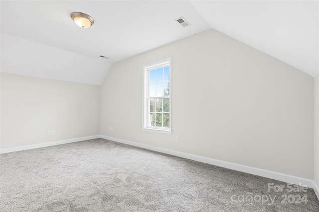 bonus room with lofted ceiling and carpet floors