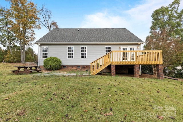 back of house featuring a lawn and a wooden deck