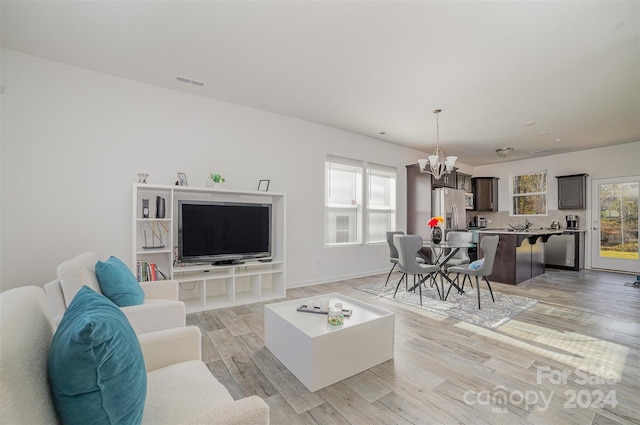 living room featuring light hardwood / wood-style flooring and an inviting chandelier