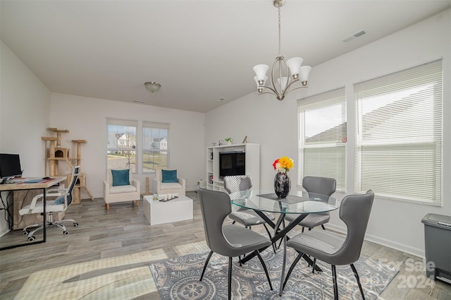 dining room with a chandelier and light hardwood / wood-style floors