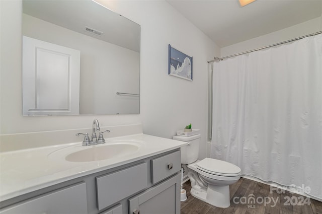 bathroom with vanity, toilet, and hardwood / wood-style flooring