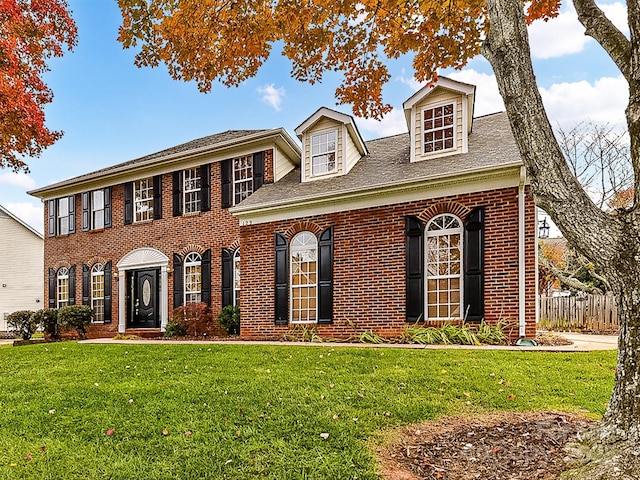 colonial-style house featuring a front yard