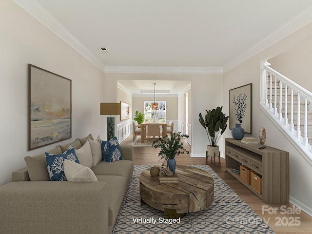 living room featuring wood-type flooring and crown molding