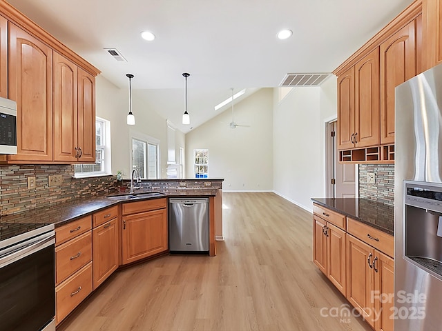 kitchen featuring tasteful backsplash, pendant lighting, stainless steel appliances, and sink