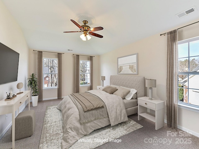 bedroom with multiple windows, light colored carpet, and ceiling fan