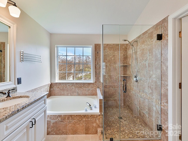 bathroom featuring plus walk in shower, vanity, and tile patterned floors