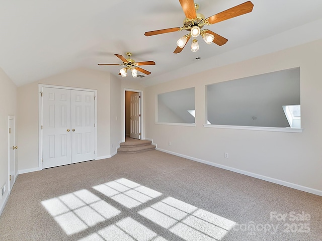 unfurnished bedroom with carpet, ceiling fan, lofted ceiling, and a closet