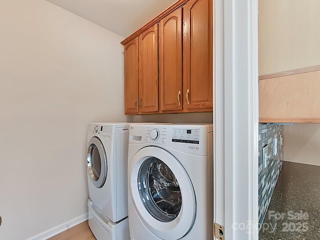 washroom with cabinets and washing machine and dryer