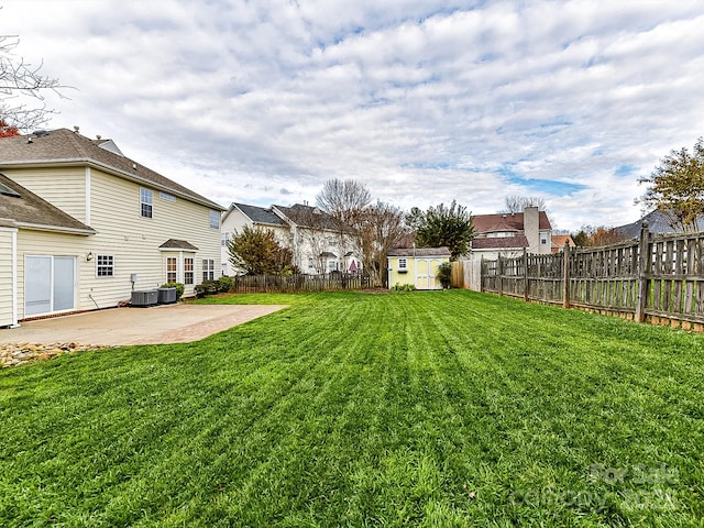 view of yard with central AC unit, a storage unit, and a patio area