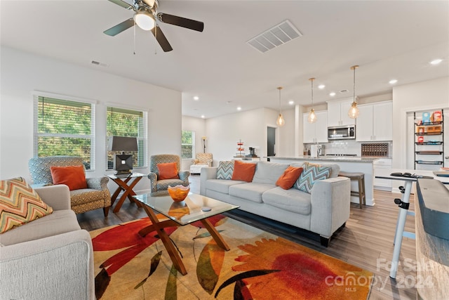 living room with dark hardwood / wood-style floors and ceiling fan