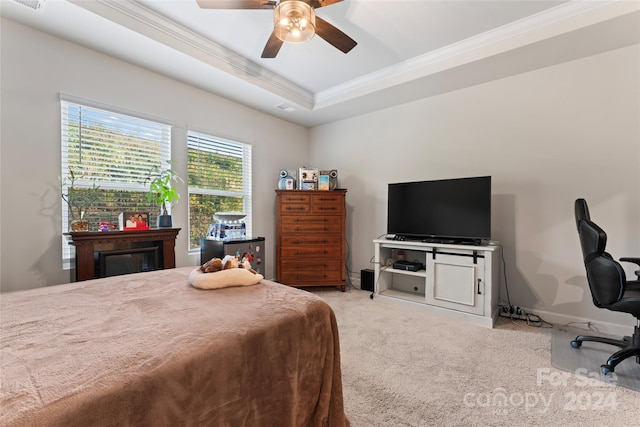 bedroom featuring ceiling fan, a raised ceiling, light carpet, and crown molding