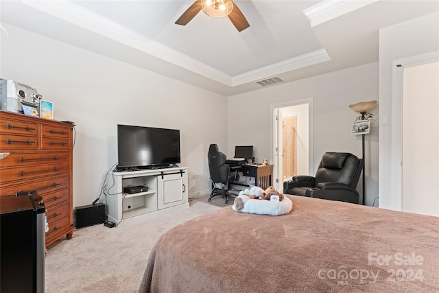 bedroom featuring ceiling fan, ornamental molding, light carpet, and a tray ceiling