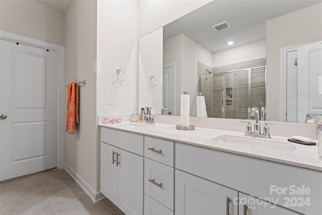 bathroom with tile patterned floors, vanity, and a shower with shower door